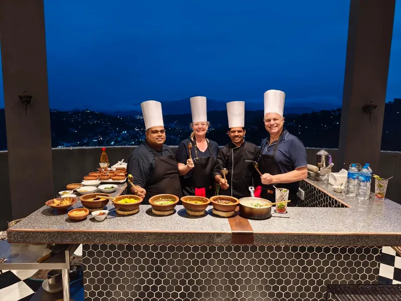 Chefs behind a table of freshly prepared dishes at dusk at The Summit Kandy