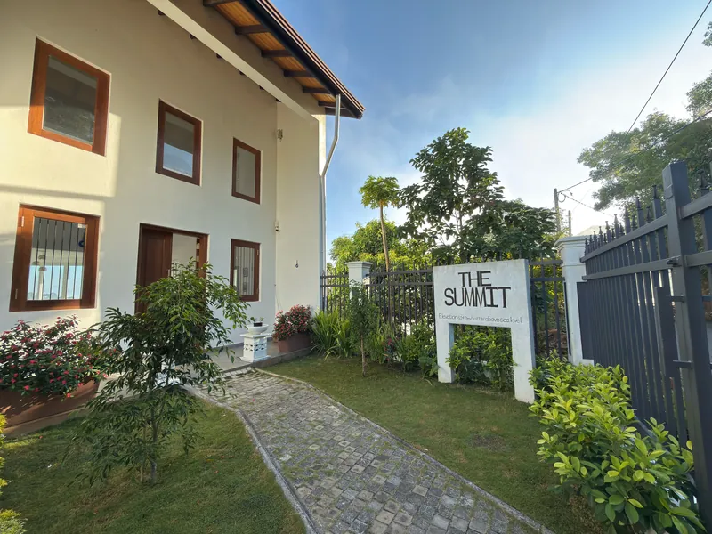 The Summit Kandy hotel exterior with garden path and the 'THE SUMMIT' elevation sign in Hanthana, Kandy