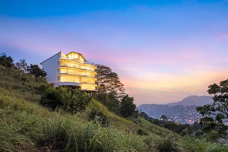 The Summit Kandy hotel lit up at dusk on the Hanthana hillside above Kandy
