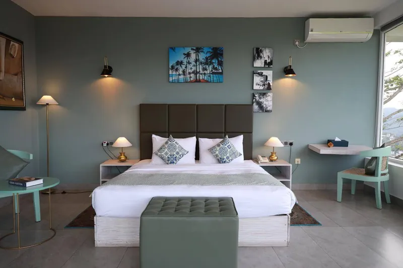 Spacious guest bedroom with framed artwork and reading lamps at The Summit Kandy