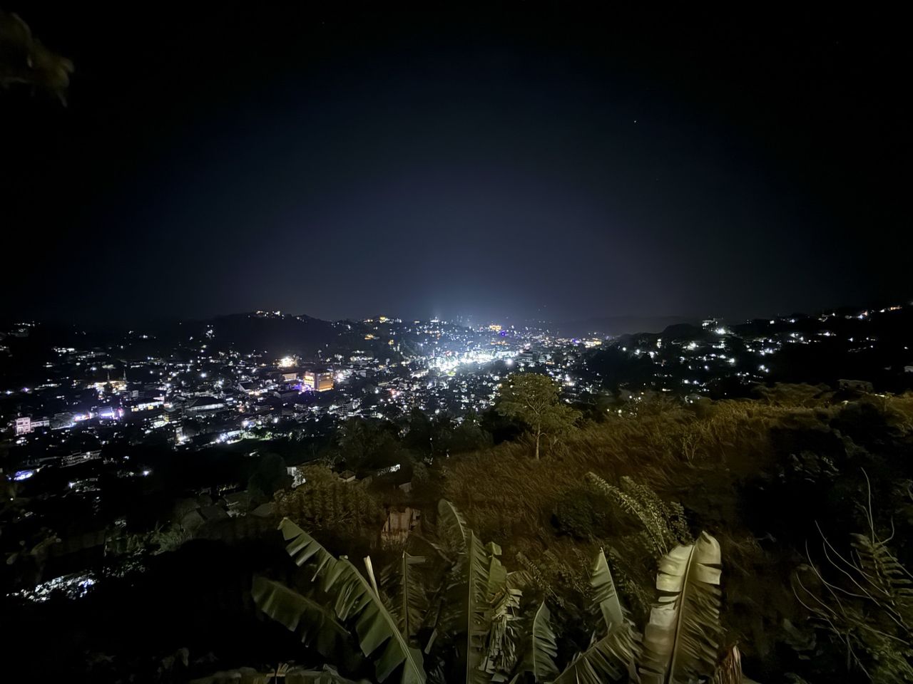 Kandy city lights glowing across the valley at night, viewed from The Summit Kandy