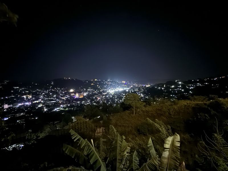 Kandy city lights glowing across the valley at night, viewed from The Summit Kandy