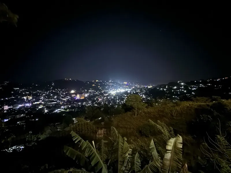 Kandy city lights glowing across the valley at night, viewed from The Summit Kandy