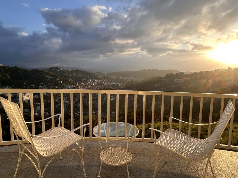 Private balcony with rattan chairs at sunset overlooking the Kandy hills at The Summit Kandy