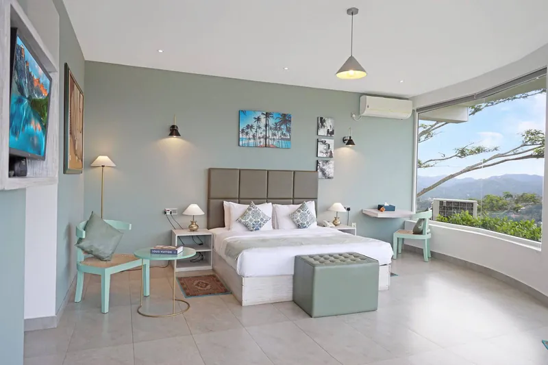 Guest bedroom with a king bed and panoramic corner windows overlooking Kandy at The Summit Kandy