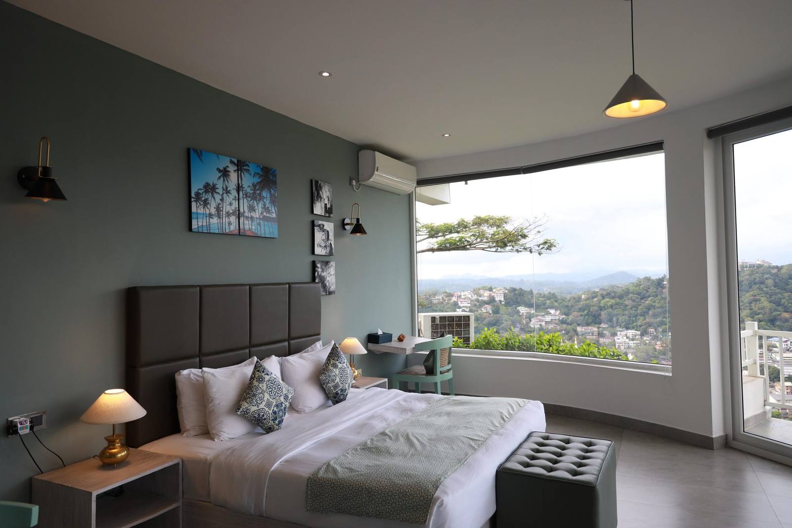 Deluxe room at The Summit Kandy with a panoramic corner window over Kandy city and the Hanthana hills