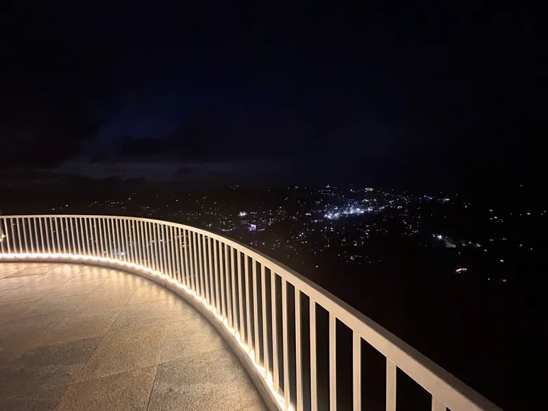 Illuminated rooftop terrace railing at night above the glittering lights of Kandy city at The Summit Kandy